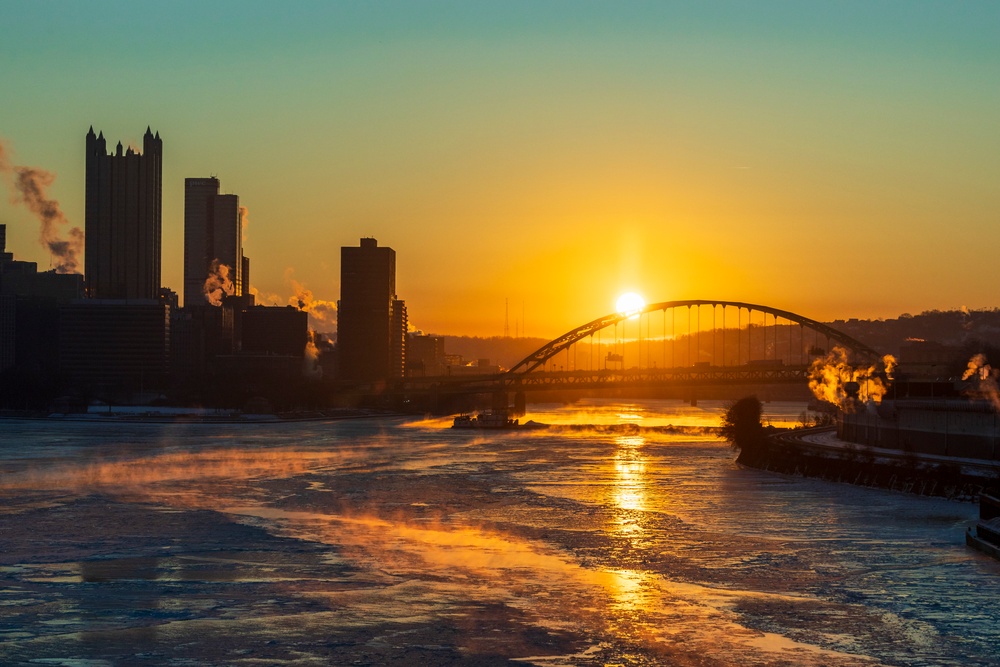 Sunfire and Ice: Towboats navigate through frozen rivers during Pittsburgh sunrise