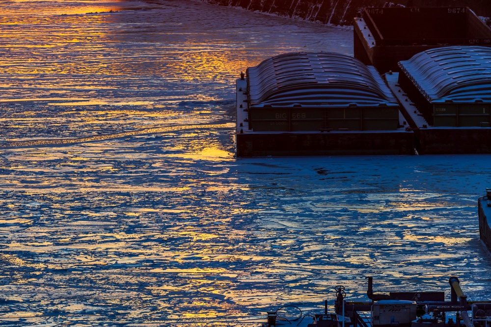 Sunfire and Ice: Towboats navigate through frozen rivers during Pittsburgh sunrise