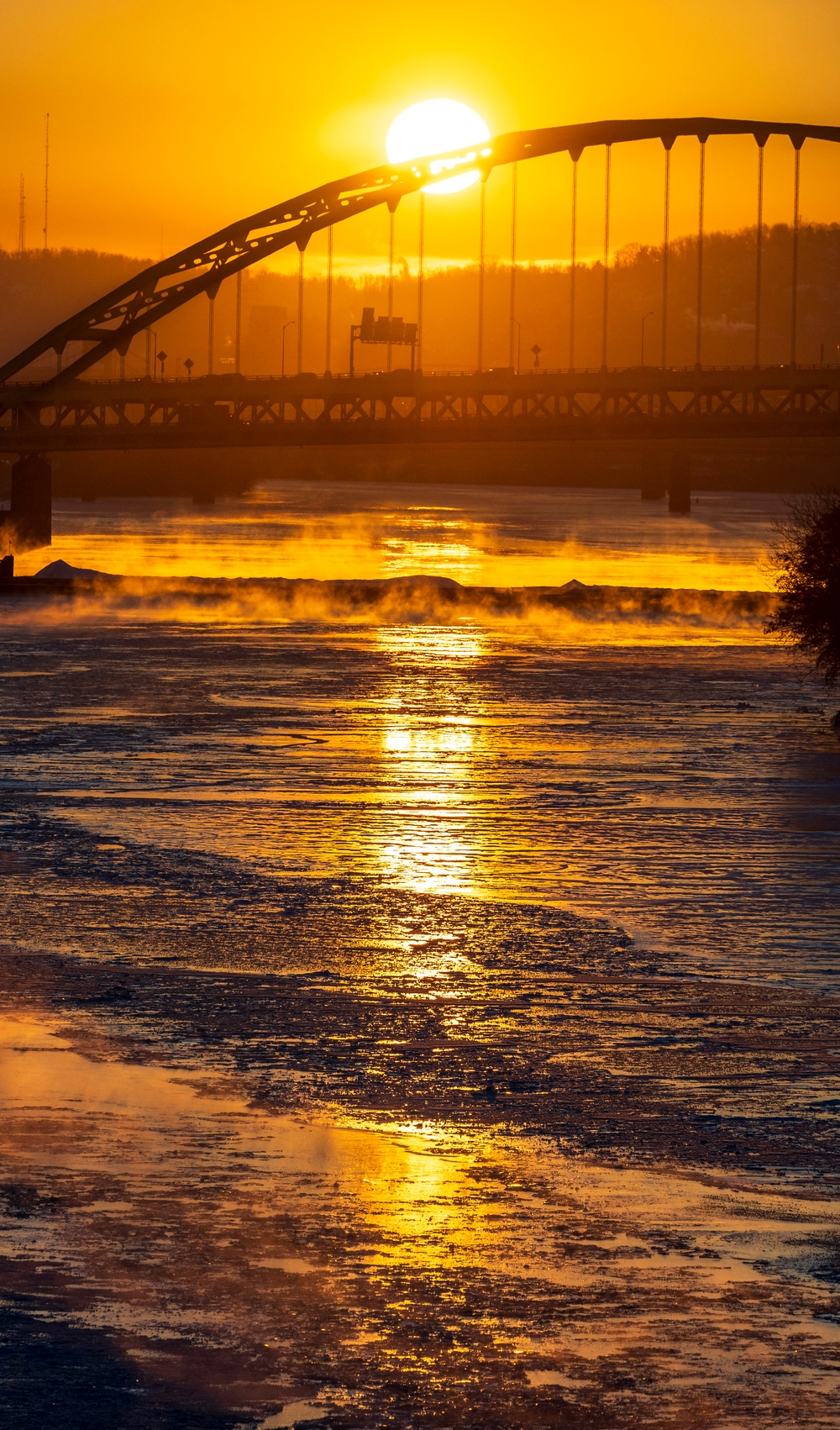 Sunfire and Ice: Towboats navigate through frozen rivers during Pittsburgh sunrise