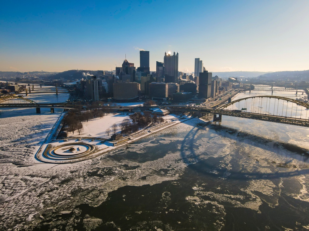 Sunfire and Ice: Towboats navigate through frozen rivers during Pittsburgh sunrise