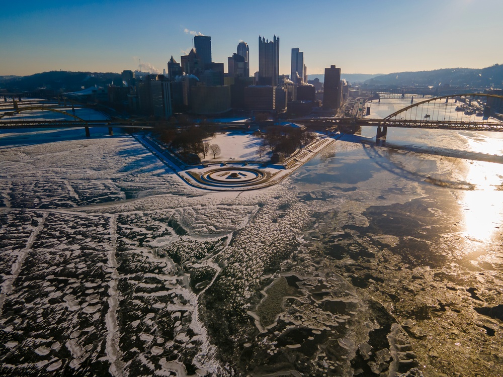 Sunfire and Ice: Towboats navigate through frozen rivers during Pittsburgh sunrise