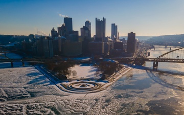 Sunfire and Ice: Towboats navigate through frozen rivers during Pittsburgh sunrise