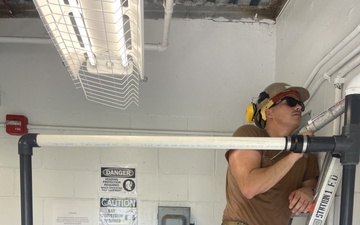 U.S. Navy Seabees with NMCB 3’s Detail Diego Garcia construct an air compressor exhaust system in support of DG Naval Support Facility