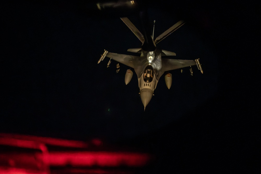 F-16 Fighting Falcons join KC-135 Stratotanker for aerial refueling over USCENTCOM at night