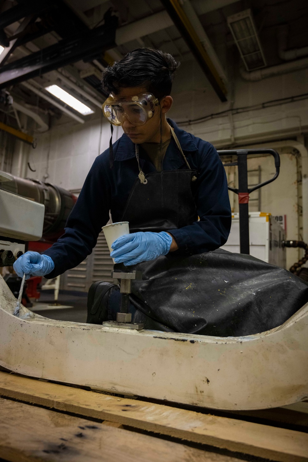 Nimitz Sailor Applies Paint Stripper To Engine Trailer Welds