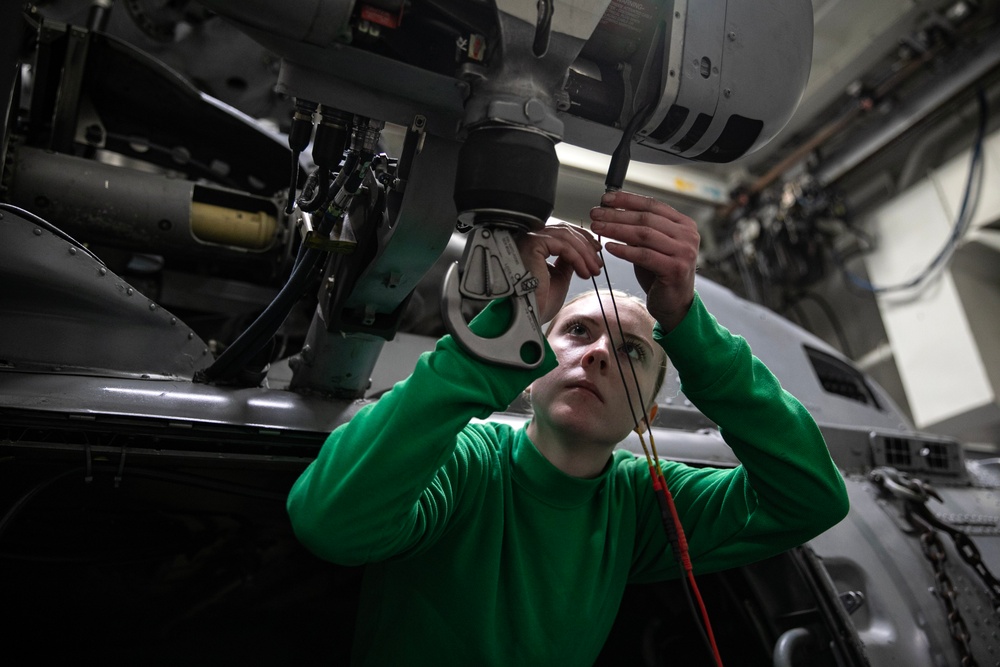 Battle Cats Conduct Maintenance on Helicopter