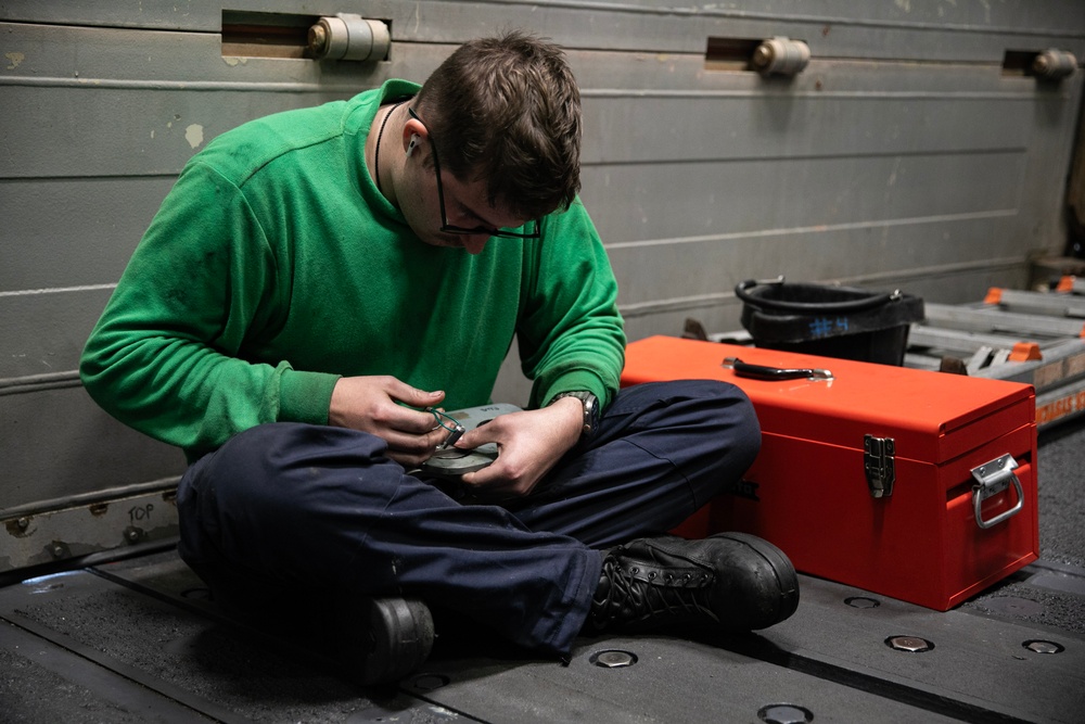 Battle Cats Perform Maintenance on Helicopter