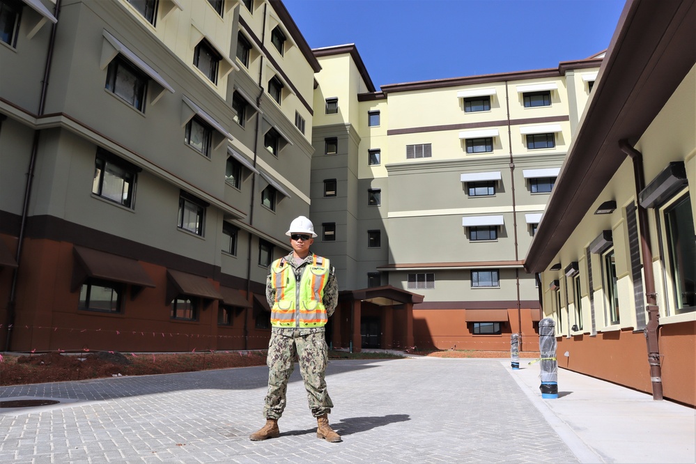 The Construction Manager for Bachelor Enlisted Quarters Poses with the Project