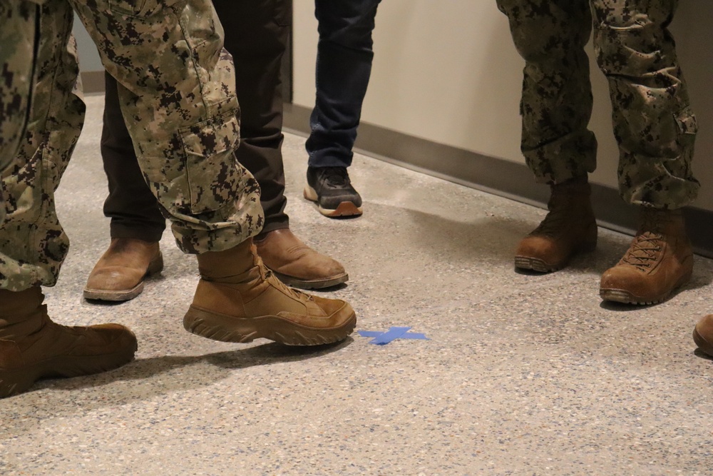 Military and Civilian Staff with the Office in Charge of Construction Point out a Defect in Floor Installation