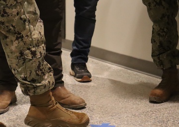 Military and Civilian Staff with the Office in Charge of Construction Point out a Defect in Floor Installation