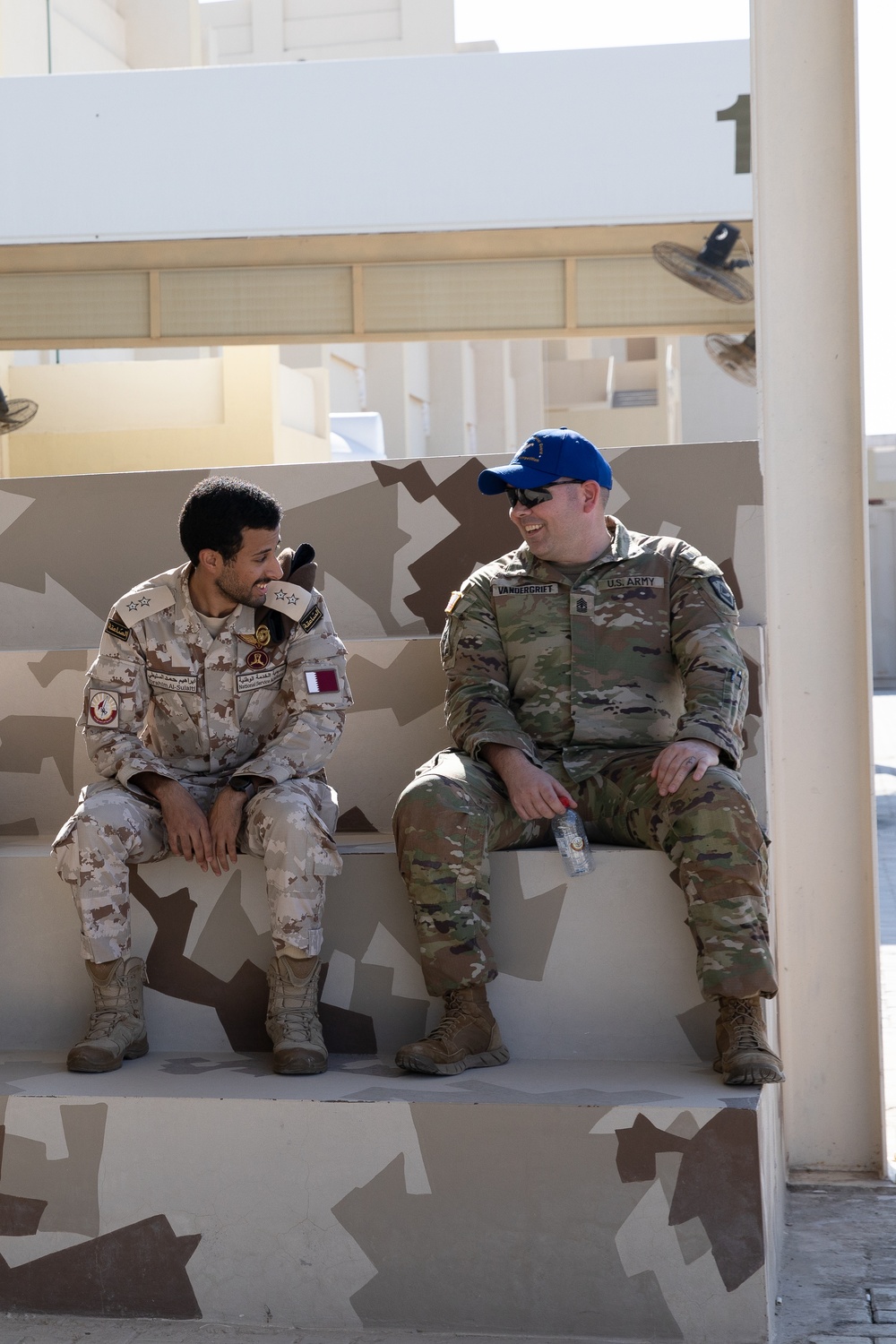 U.S. Army 1st Sgt. Christopher Vandergrift smiles while discussing the events of the Best Warrior Competition with National Service Academy 1st Lt. Ibrihim Al-Sulalti