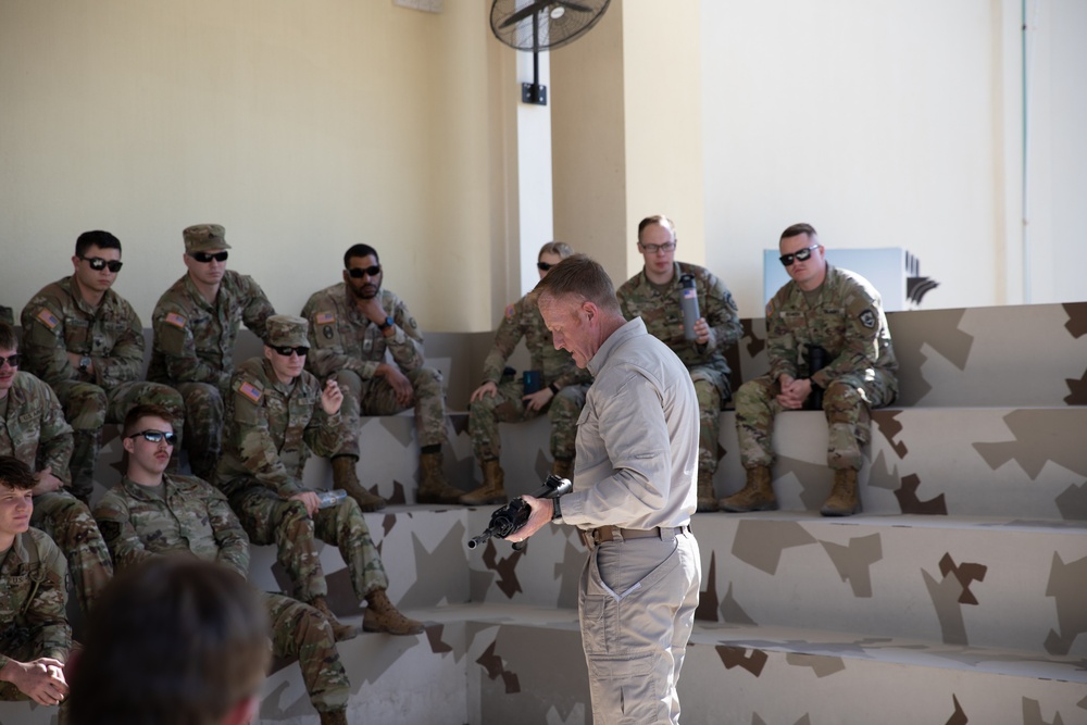 National Service Academy instructor teaches Best Warrior Competitors weapons familiarization class