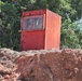 A Contractor Waves from Within a Blast Box Used for UXO Removal During Construction of Camp Blaz