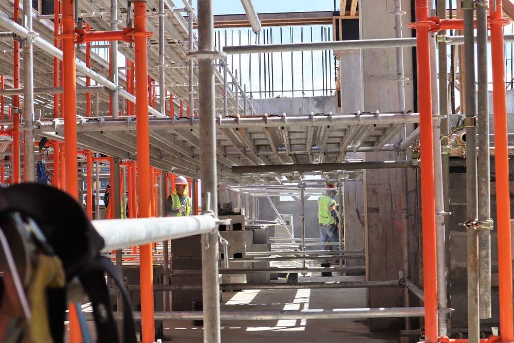 Construction Workers Maintain a Tidy Worksite Between Scaffolding of a Building Under Construction on Marine Corps Base Camp Blaz