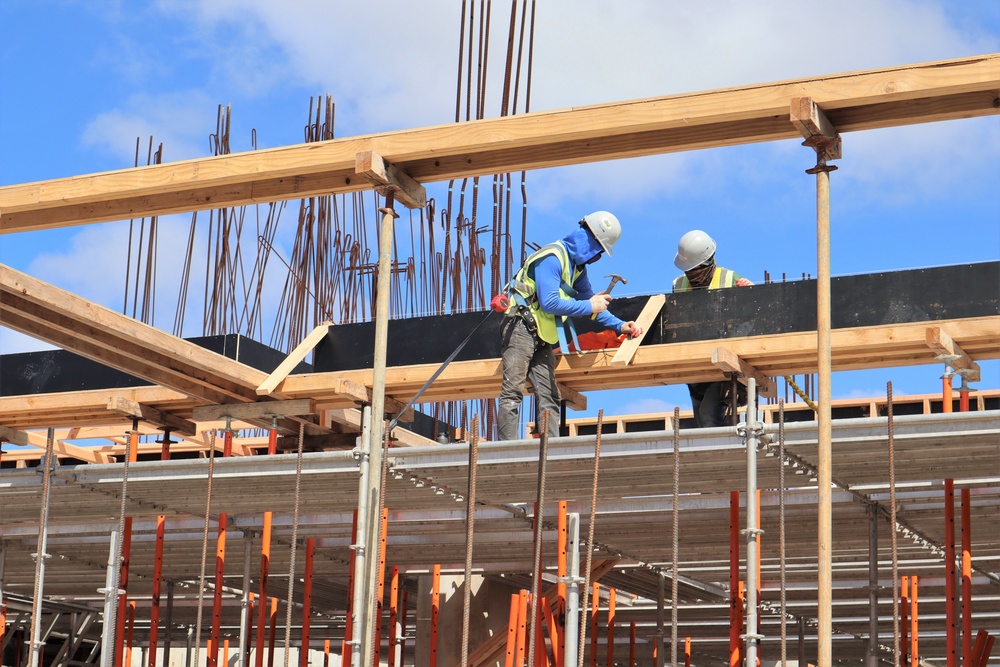 Construction Workers Work on the Envelope of a Building Under Construction