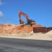 An Excavator Moves Soil During Construction on Marine Corps Base Camp Blaz