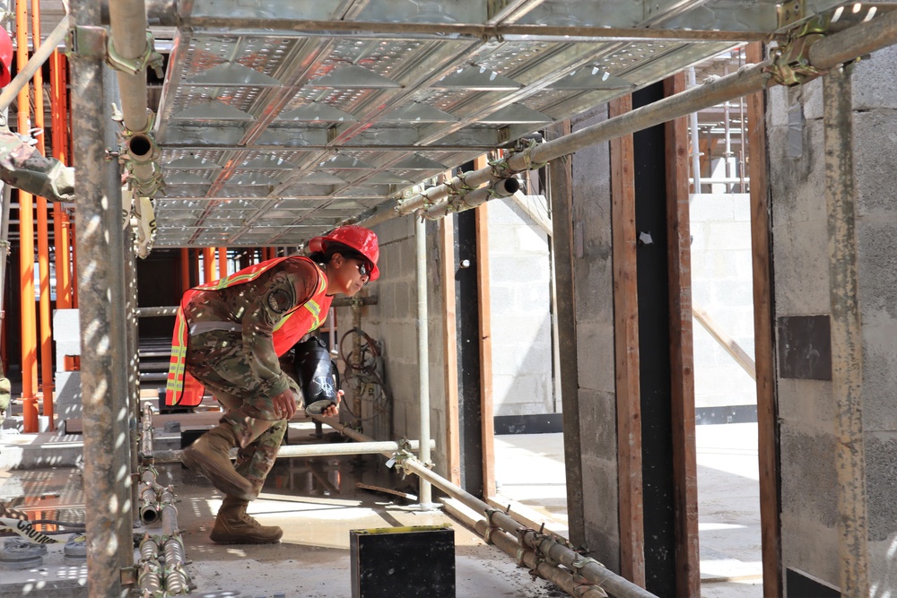 A Civil Engineering Officer Ducks Under Scaffolding While Touring a Building Under Construction on Marine Corps Base Camp Blaz