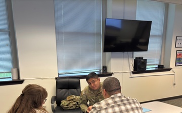 An airman and other Summit Room volunteers practice the skills from WRAIR-West’s peer ambassador training by role-playing a peer-to-peer conversation about sharing on-base resources.