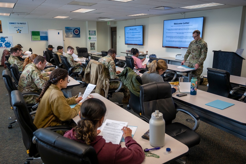 Major Osgood, Deputy Director of the Walter Reed Army Institute of Research – West, goes over the welcome letter with the Air Force trainees at peer ambassador training.