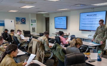 Major Osgood, Deputy Director of the Walter Reed Army Institute of Research – West, goes over the welcome letter with the Air Force trainees at peer ambassador training.