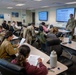 Major Osgood, Deputy Director of the Walter Reed Army Institute of Research – West, goes over the welcome letter with the Air Force trainees at peer ambassador training.