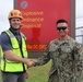 The Project Manager for the Newly-Finished EOD Building Shakes Hands with OICC MCM's Construction Manager at Building Turnover