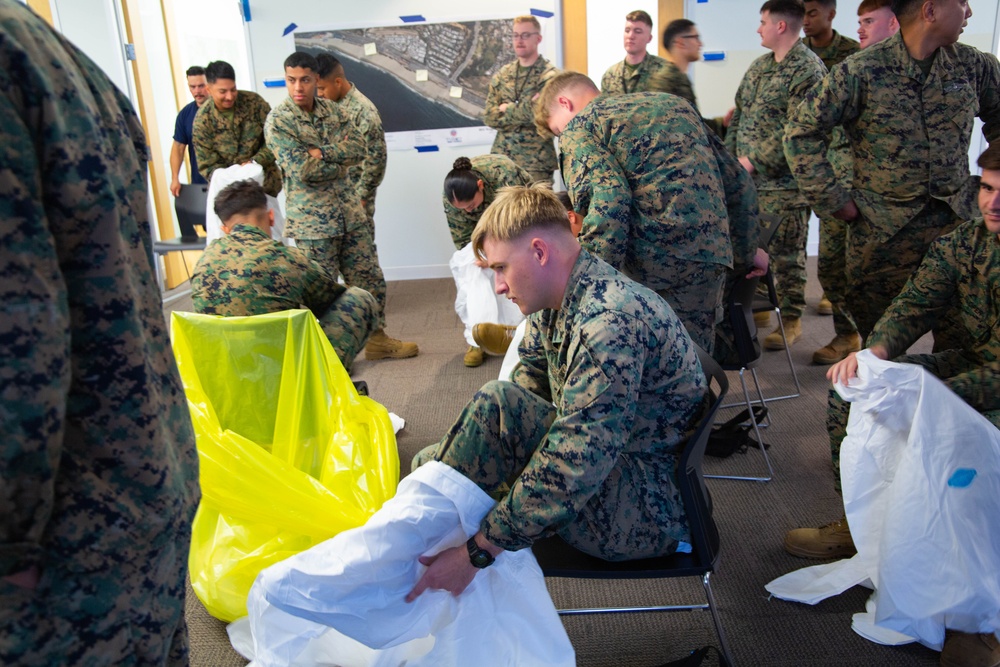 U.S. Marine from 1MLG Removes Personal Protection Equipment