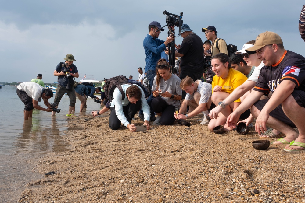 U.S. Navy Sailors release baby sea turtles into ocean during Multilateral Naval Exercise Komodo 2025 community relations project