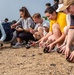 U.S. Navy Sailors release baby sea turtles into ocean during Multilateral Naval Exercise Komodo 2025 community relations project