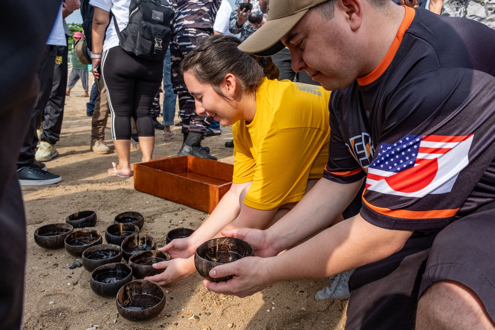 U.S. Navy Sailors release baby sea turtles into ocean during Multilateral Naval Exercise Komodo 2025 community relations project