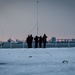 USS Gerald R. Ford (CVN 78) Sailors observe colors during a winter storm