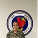 PS1 Cook stands in front of Navy Reserve emblem