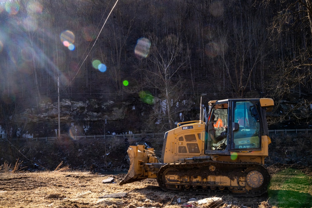 Local County Vehicles Work to Clear Mud After Flooding