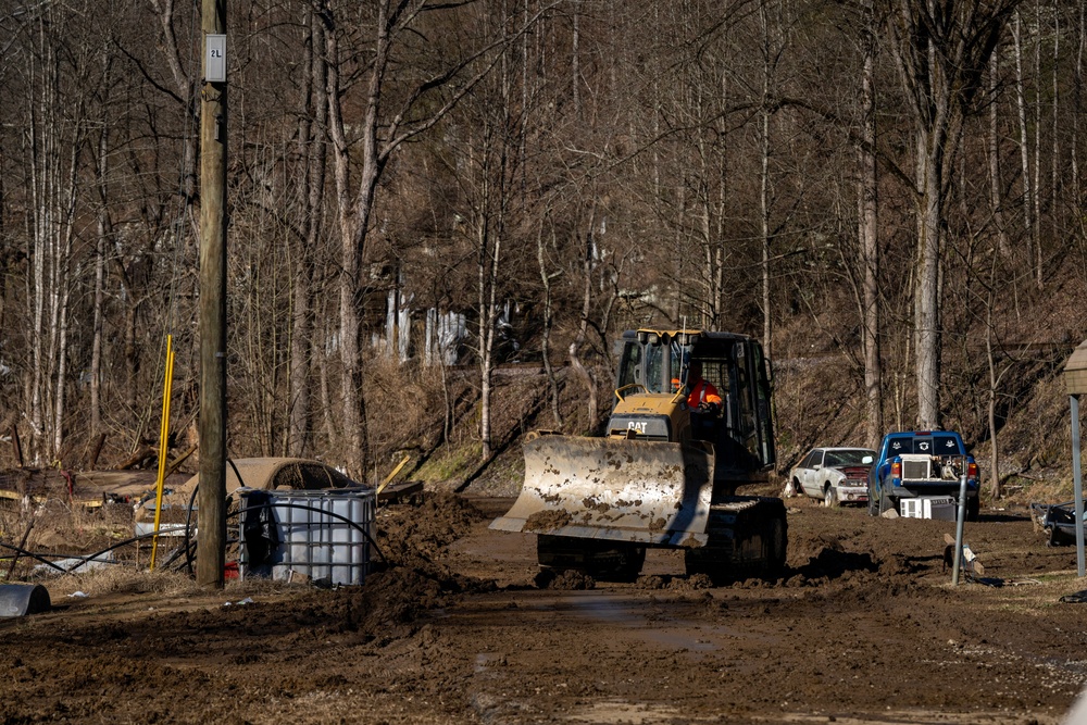 Local County Vehicles Work to Clear Mud After Flooding