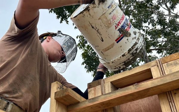 Placing concrete for schoolhouse