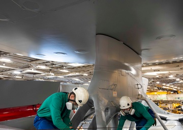 French sailors perform maintenance on an E-2C Hawkeye aboard FS Charles De Gaulle