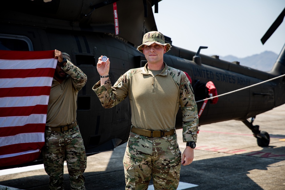 U.S. Air Force Tech. Sgt. Zachary Quicke receives a challenge coin after taking the oath of reenlistment in Thailand, during Joint Exercise Cobra Gold 25