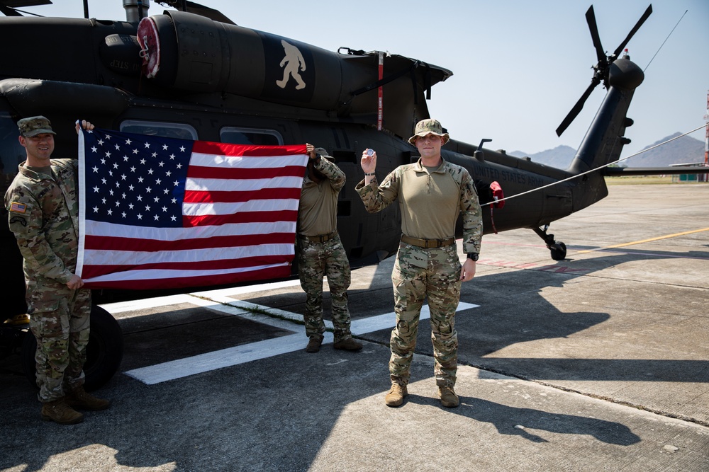 U.S. Air Force Tech. Sgt. Zachary Quicke receives a challenge coin after taking the oath of reenlistment in Thailand, during Joint Exercise Cobra Gold 25