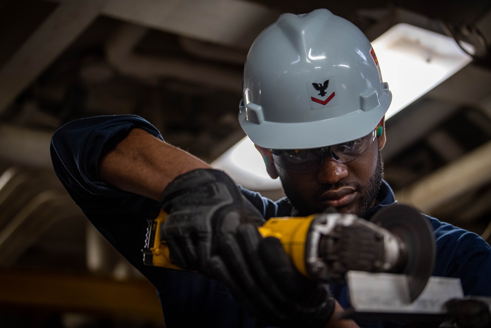 USS Ronald Reagan (CVN 76) Sailor cuts Angle Irons