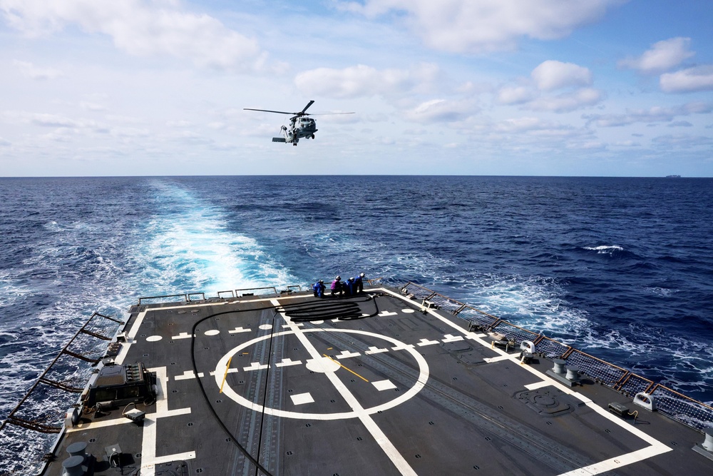 USS Gravely conducts a helicopter in-flight refueling evolution