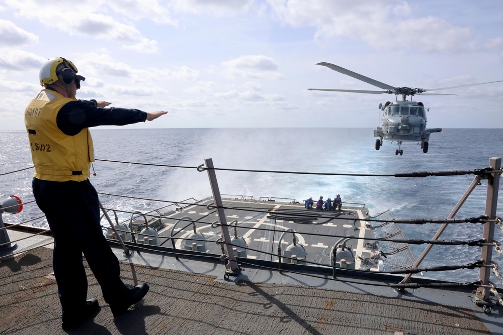 USS Gravely conducts a helicopter in-flight refueling evolution
