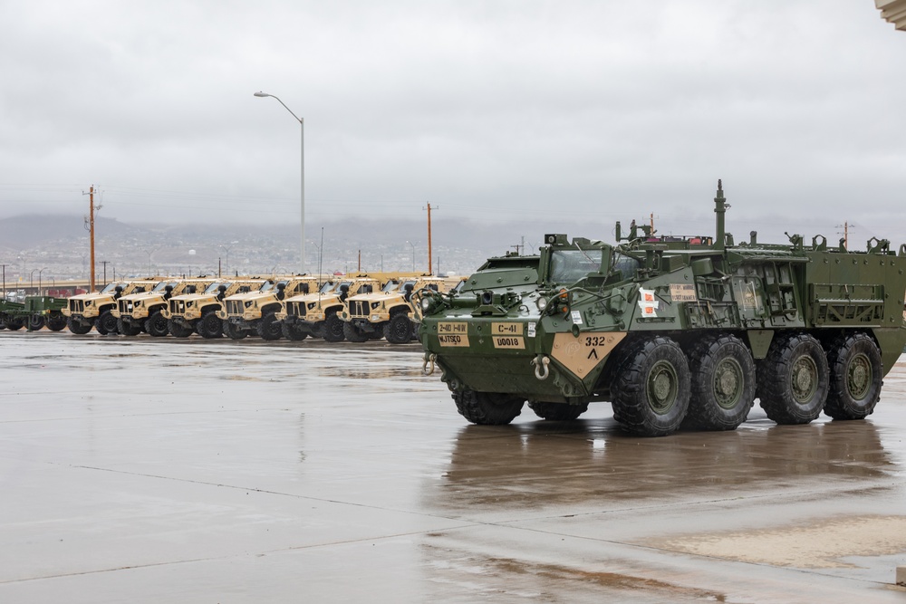 U.S. Soldiers move and ground guide Stryker combat vehicles to a motorpool