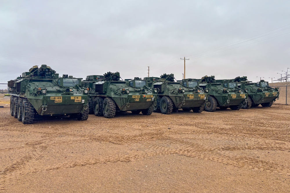 U.S. Soldiers move and ground guide Stryker combat vehicles to a motorpool