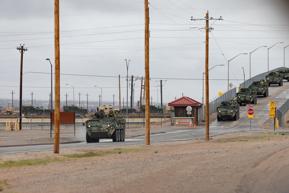 U.S. Soldiers move and ground guide Stryker combat vehicles to a motorpool