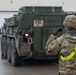 U.S. Soldiers move and ground guide Stryker combat vehicles to a motorpool