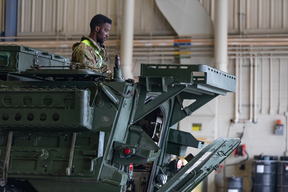 U.S. Soldiers move and ground guide Stryker combat vehicles to a motorpool