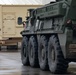 U.S. Soldiers move and ground guide Stryker combat vehicles to a motorpool