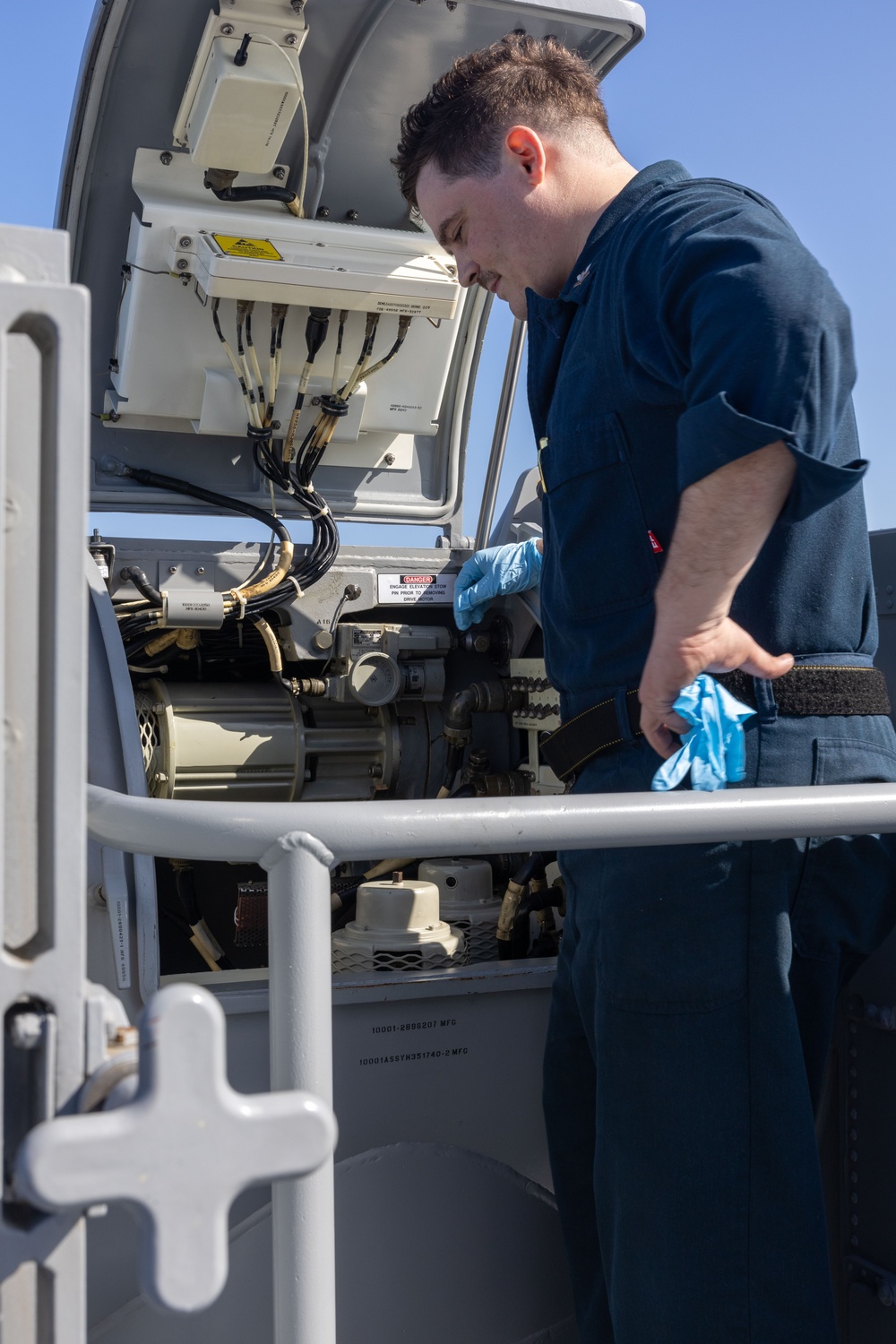 Fire Controlmen onboard USS Iwo Jima perform maintenance on NATO Sea Sparrow