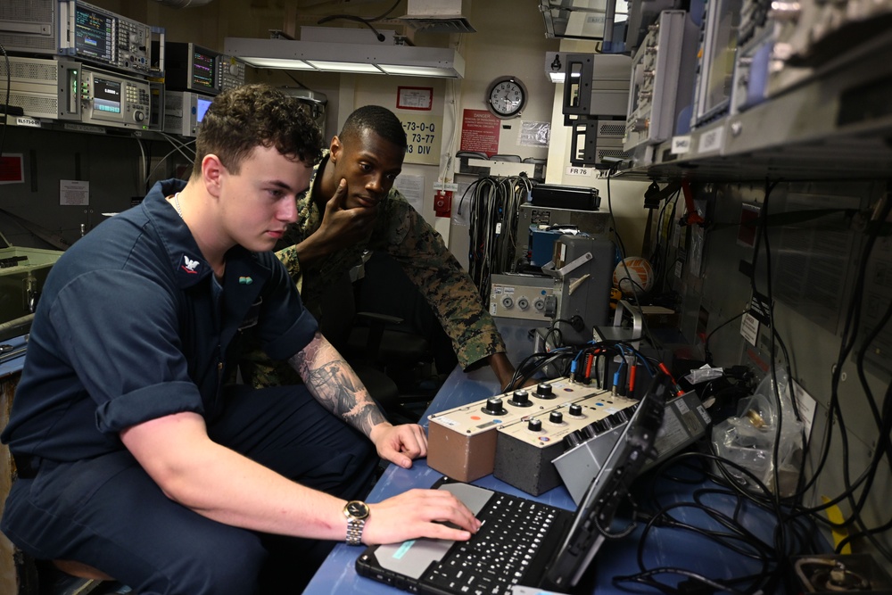 Sailor and Marines Calibrate Equipment On Board USS Iwo Jima