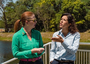 Carolina Maran, District Resiliency Officer, South Florida Water Management District, stands with Eva Velez as shebriefs the Transportation and Infrastructure subcommittee staff delegates, and partners at S-29 structure in Miami